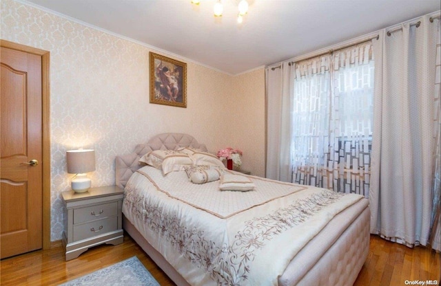 bedroom featuring hardwood / wood-style floors and crown molding