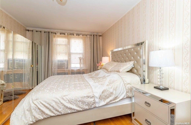 bedroom featuring hardwood / wood-style floors and ornamental molding