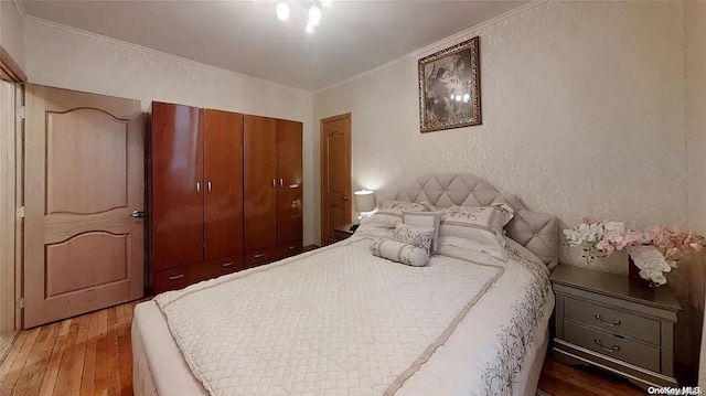 bedroom with hardwood / wood-style flooring and ornamental molding