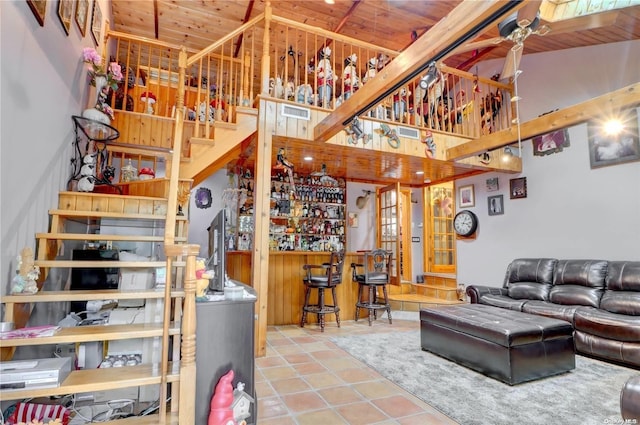 tiled living room featuring bar and wooden ceiling