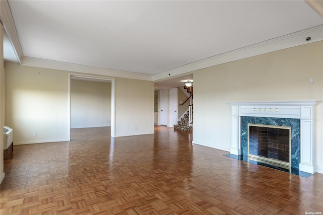 unfurnished living room featuring parquet floors, crown molding, and a premium fireplace