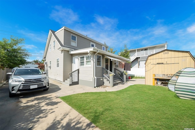 view of front of home featuring a shed and a front lawn