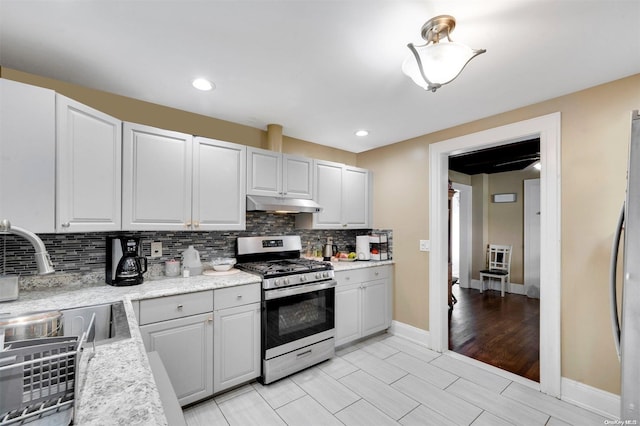 kitchen featuring decorative backsplash, appliances with stainless steel finishes, light wood-type flooring, and white cabinets