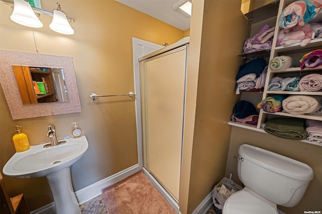 bathroom featuring toilet and an enclosed shower