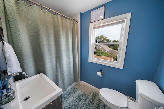 bathroom featuring tile patterned floors, a shower with curtain, toilet, and sink