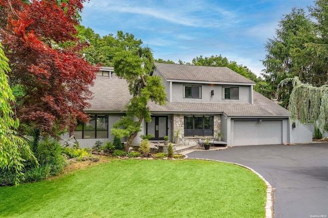 view of front of home with a front lawn and a garage