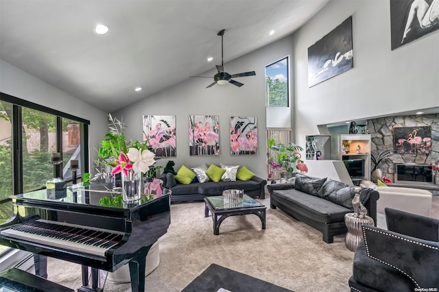 carpeted living room featuring a stone fireplace, ceiling fan, and high vaulted ceiling