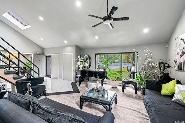 living room featuring ceiling fan, light colored carpet, high vaulted ceiling, and a skylight