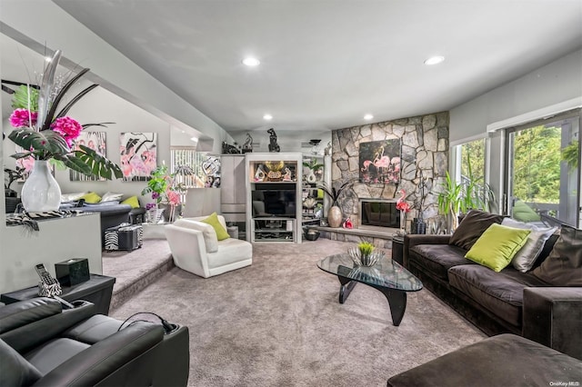 carpeted living room with a stone fireplace