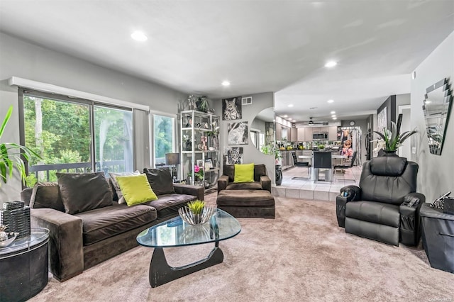 carpeted living room with ceiling fan