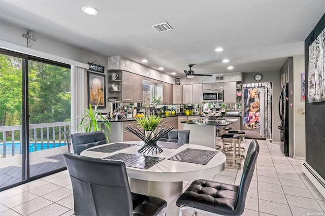 tiled dining room featuring ceiling fan and a baseboard radiator