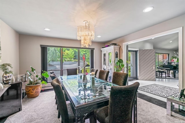 dining area featuring a notable chandelier, light colored carpet, and baseboard heating