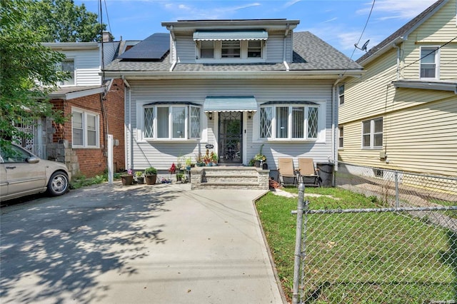 bungalow-style house featuring solar panels and a front yard