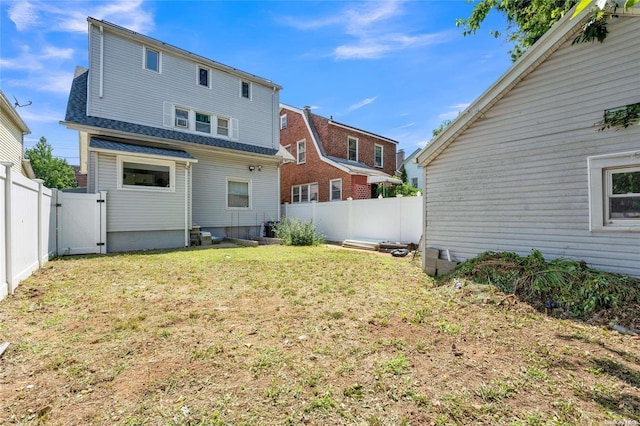 rear view of property featuring a lawn