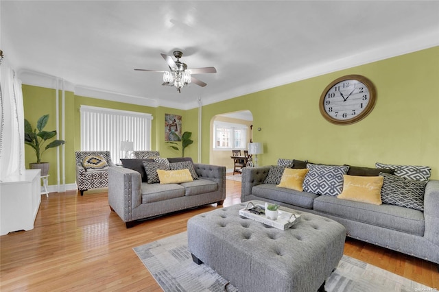 living room with ceiling fan, crown molding, and light hardwood / wood-style floors