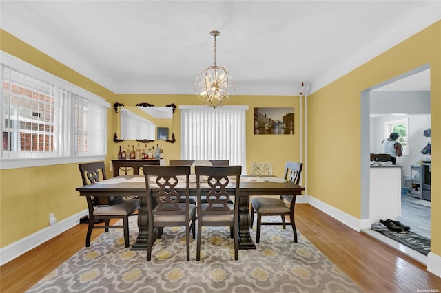 dining space with wood-type flooring and an inviting chandelier