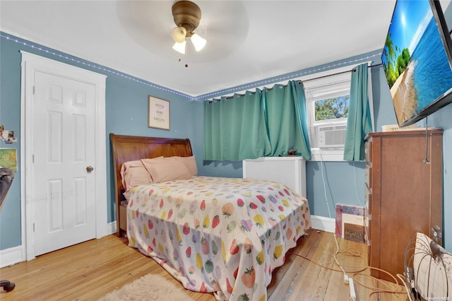 bedroom featuring ceiling fan, light wood-type flooring, and radiator