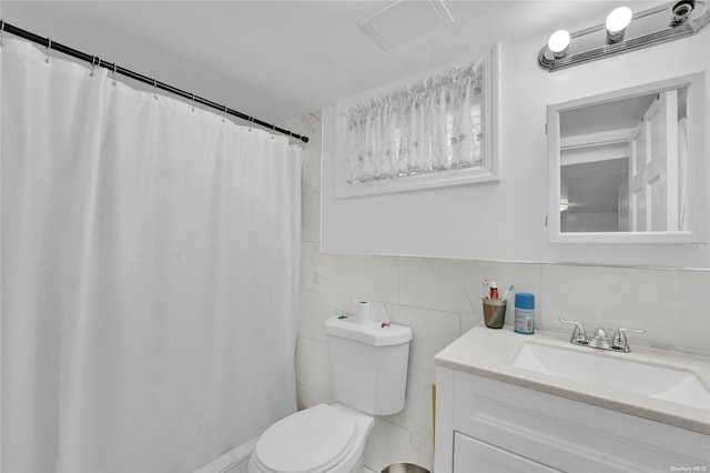 bathroom featuring curtained shower, vanity, tile walls, and toilet