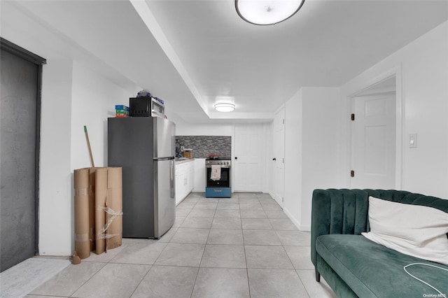 kitchen featuring white cabinets, light tile patterned floors, appliances with stainless steel finishes, and tasteful backsplash