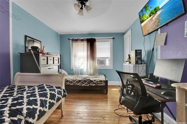 bedroom featuring hardwood / wood-style flooring, ceiling fan, and ornamental molding