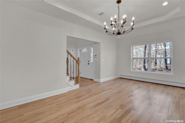 unfurnished dining area featuring a chandelier, a tray ceiling, a baseboard radiator, and light hardwood / wood-style flooring