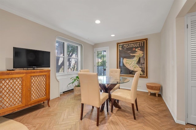 dining room with ornamental molding and light parquet flooring