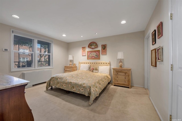 bedroom featuring light colored carpet and radiator