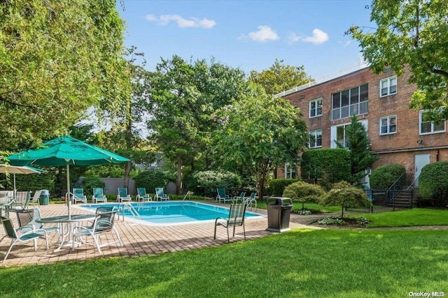 view of swimming pool featuring a yard and a patio