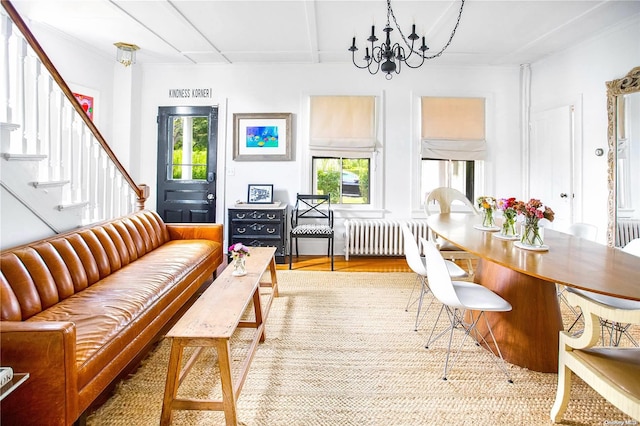 living room with radiator, beamed ceiling, a notable chandelier, and hardwood / wood-style flooring