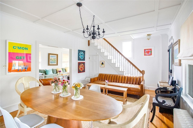 dining space with hardwood / wood-style floors, radiator heating unit, coffered ceiling, and a chandelier