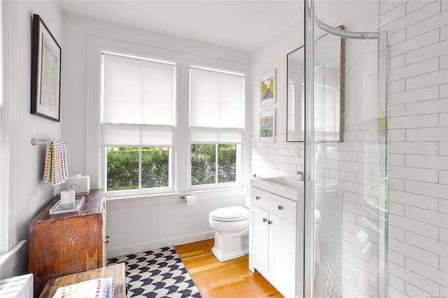 bathroom with wood-type flooring, vanity, toilet, and walk in shower