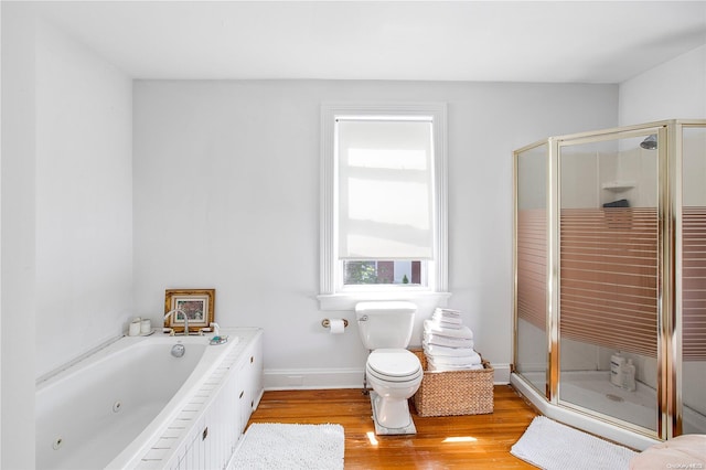 bathroom featuring hardwood / wood-style flooring, separate shower and tub, and toilet