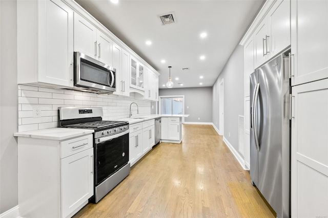 kitchen featuring appliances with stainless steel finishes, backsplash, and white cabinetry