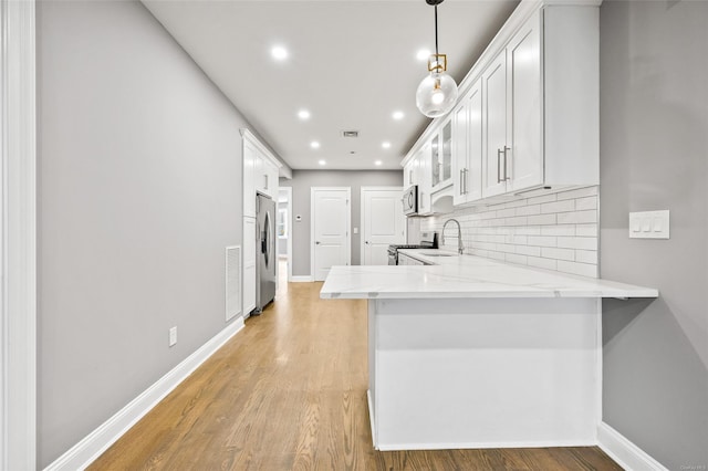 kitchen featuring kitchen peninsula, sink, white cabinets, and appliances with stainless steel finishes