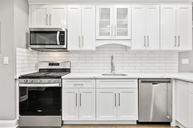 kitchen with sink, white cabinetry, stainless steel appliances, and tasteful backsplash