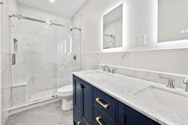 bathroom featuring a shower with door, vanity, tile walls, and toilet