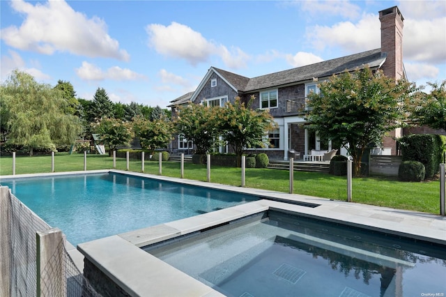 view of pool with a yard and an in ground hot tub