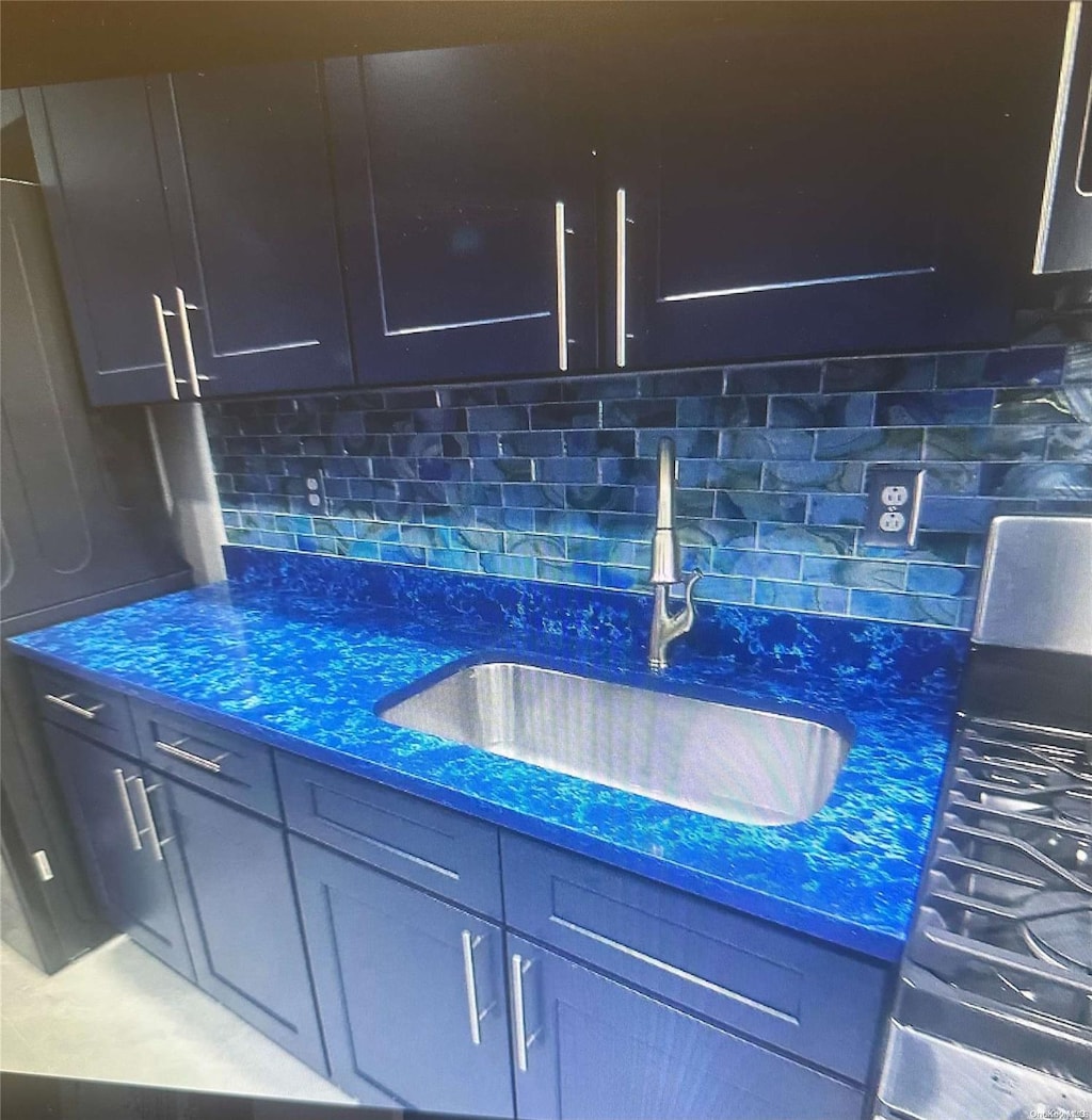 kitchen with sink, dark stone counters, and tasteful backsplash