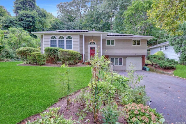 bi-level home featuring a garage and a front lawn