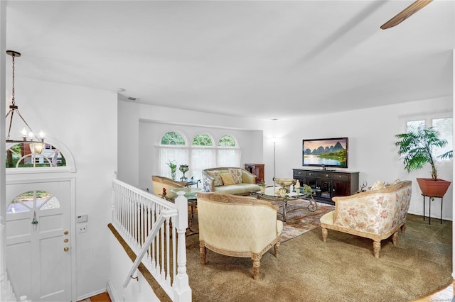 carpeted living room featuring a chandelier