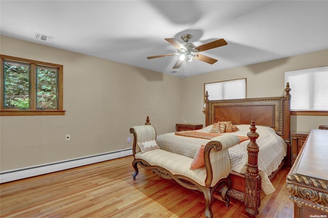 bedroom with baseboard heating, ceiling fan, and light hardwood / wood-style flooring