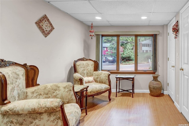 sitting room with a paneled ceiling and light hardwood / wood-style floors