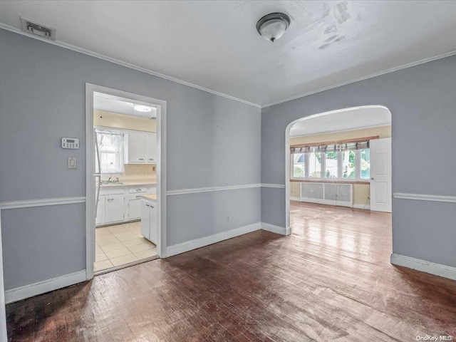 unfurnished room with crown molding and light hardwood / wood-style floors