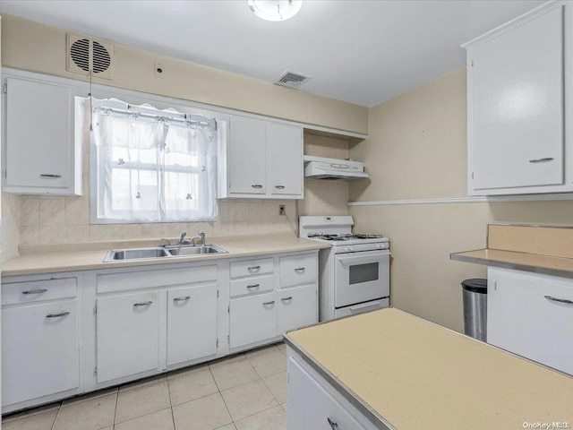 kitchen featuring white gas range, white cabinetry, sink, and decorative backsplash