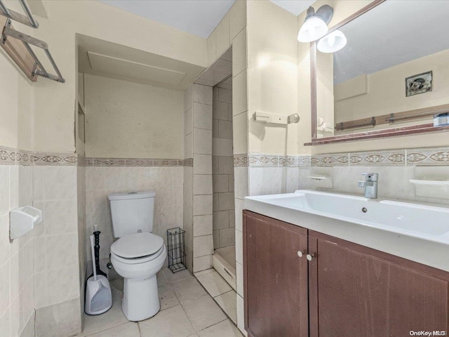 bathroom featuring tile patterned flooring, vanity, toilet, and tile walls