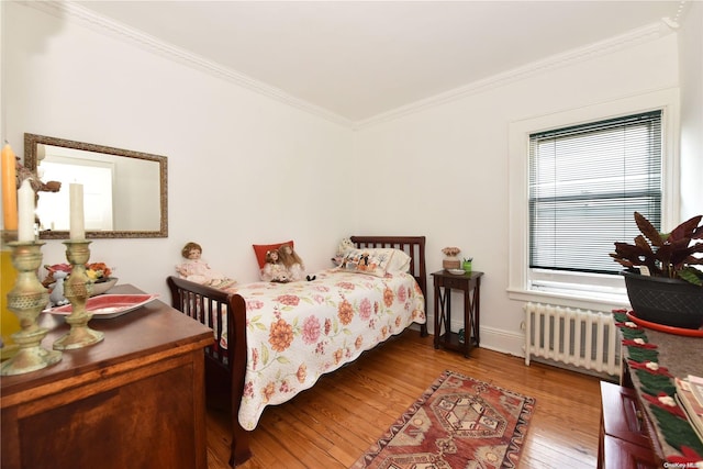 bedroom with light hardwood / wood-style floors, ornamental molding, and radiator