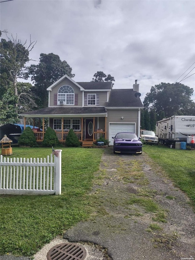 view of front property featuring covered porch, a garage, and a front yard