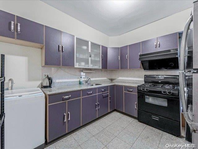 kitchen featuring black range with gas stovetop, dark brown cabinetry, sink, and tasteful backsplash