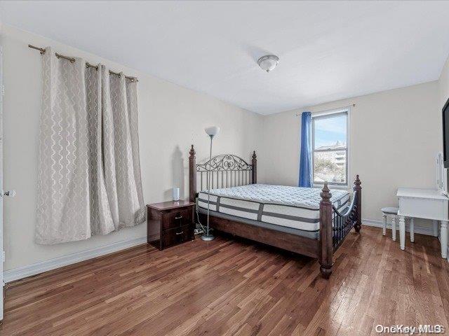 bedroom with dark wood-type flooring