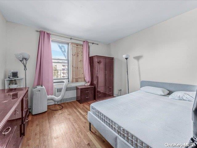 bedroom with hardwood / wood-style floors and radiator